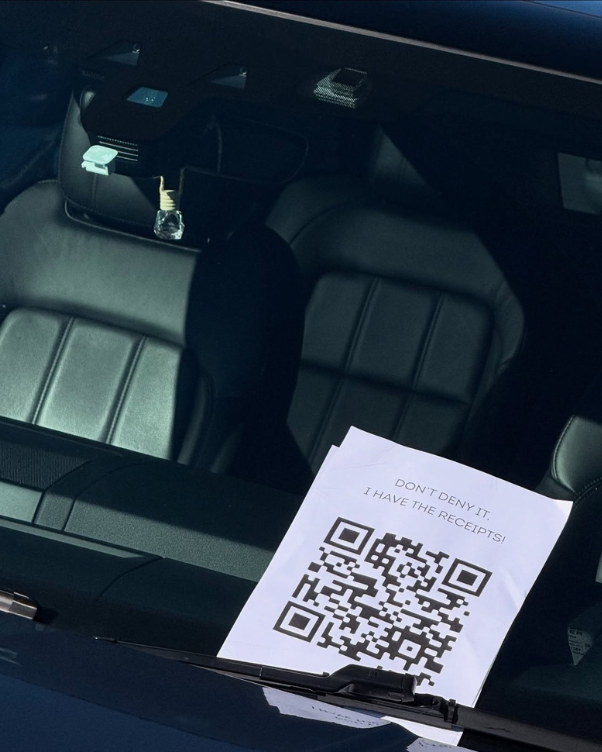 Note on a car windshield with a large QR code and the message 'Don't deny it! I have the receipts!' on the paper in the driver's area
