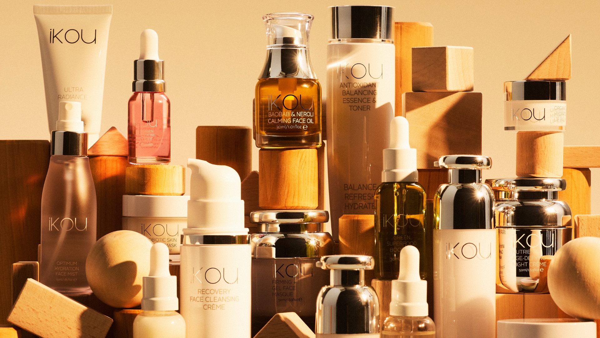 Assorted skincare bottles and jars arranged on wooden blocks, backlit with warm light.